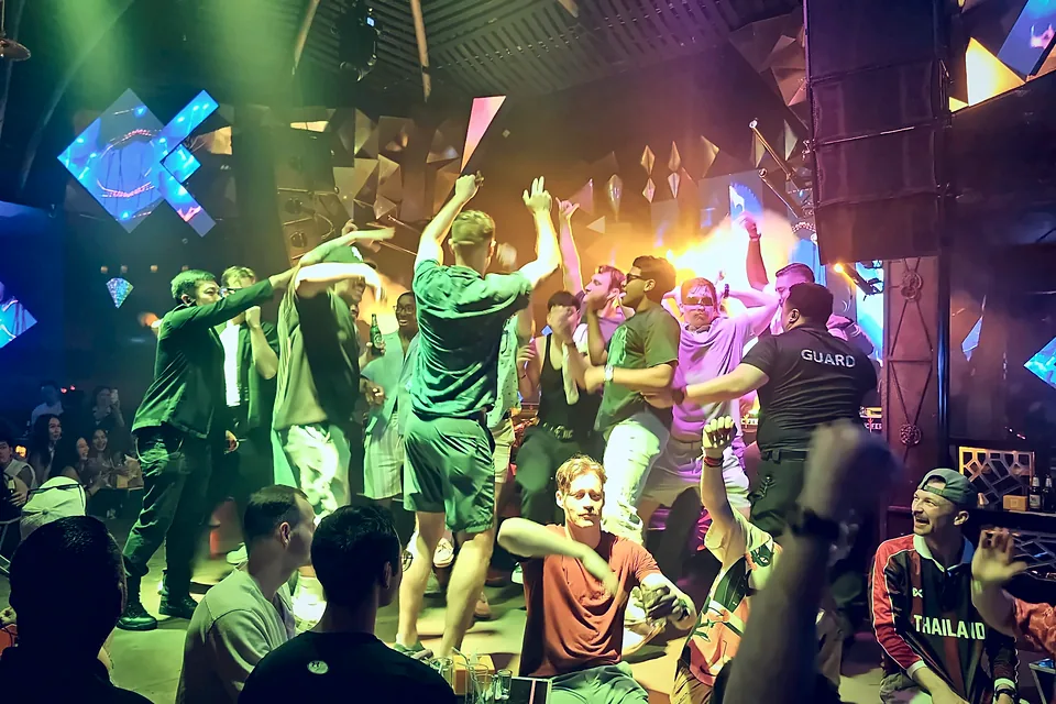 Guests dancing on the stage at Lucifer Club in Pattaya, arms in the air